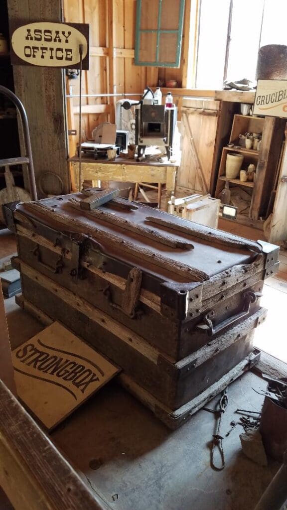 Antique strongbox and historical gold mining equipment inside the Assay Office display at Big Thunder Gold Mine in Keystone, SD.