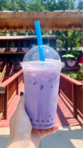Iced purple taro milk tea with boba in a clear cup with a blue straw from Big Thunder Coffee Cabin at Big Thunder Gold Mine in Keystone, SD.