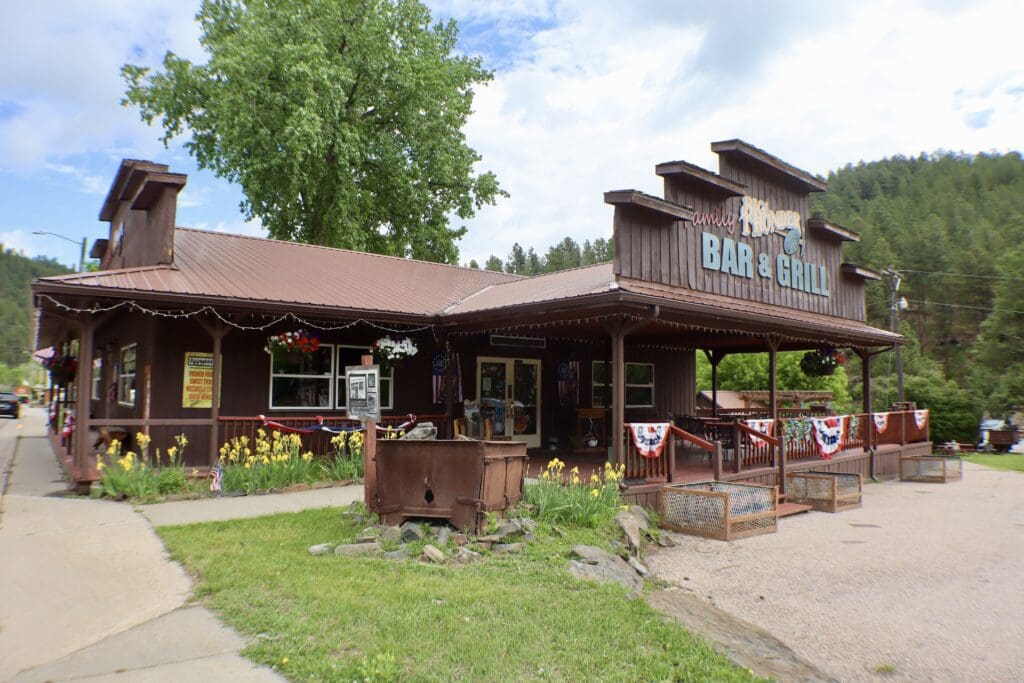 Big Thunder Bar and Grill rustic wooden storefront with outdoor patio at Big Thunder Gold Mine in Keystone South Dakota.