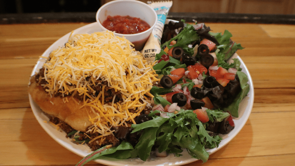Traditional Indian Taco served on warm fry bread with shredded cheese, diced tomatoes, and black olives at Big Thunder Bar & Grill in Keystone, SD.