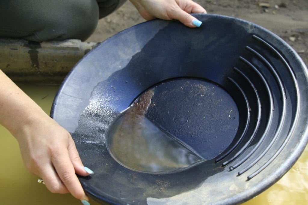 A visitor pans for gold using pay dirt at Big Thunder Gold Mine, a historic tourist attraction in Keystone, SD near the Black Hills.